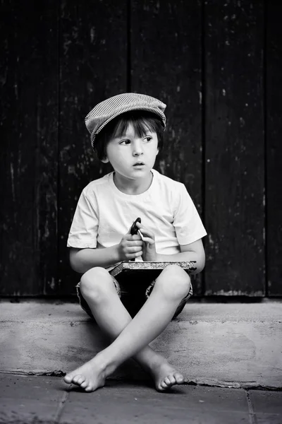 Cute little child, boy, holding big metal key and a book, willin — 图库照片