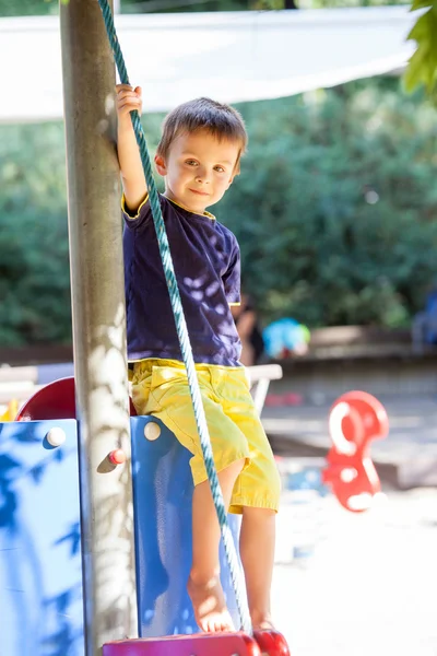 Menino bonito da criança, brincando no playground — Fotografia de Stock
