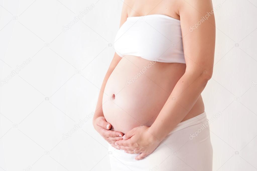 Belly of a pregnant woman on white background, isolated