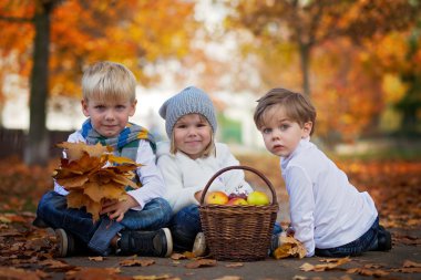 Three cute kids in the park, playing 