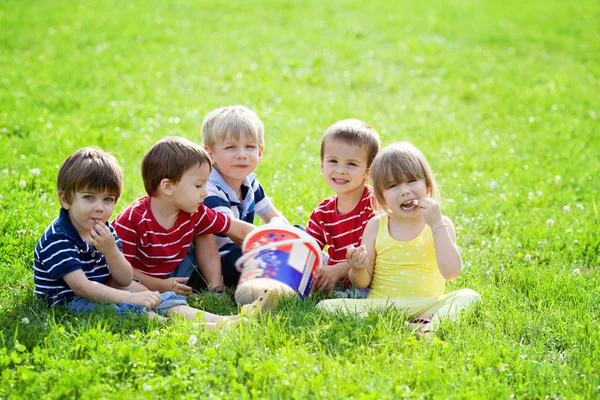 Cinco crianças adoráveis, comendo pipocas no parque — Fotografia de Stock