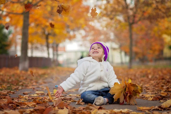 Adorable little girl in the park, playing with leaves — 스톡 사진