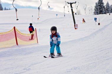 Mavi ceket ve bir kask ile sevimli küçük çocuk Kayak