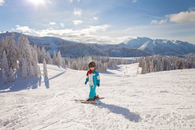Mavi ceket ve bir kask ile sevimli küçük çocuk Kayak