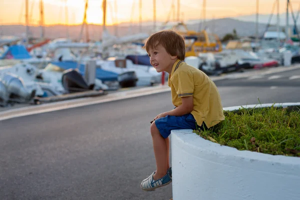 Dolce bambino, bambino, seduto e guardando il porto — Foto Stock