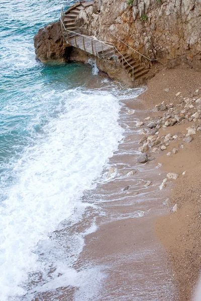 Uma escadaria em torno de uma parede de rocha íngreme, conectando duas praias em — Fotografia de Stock