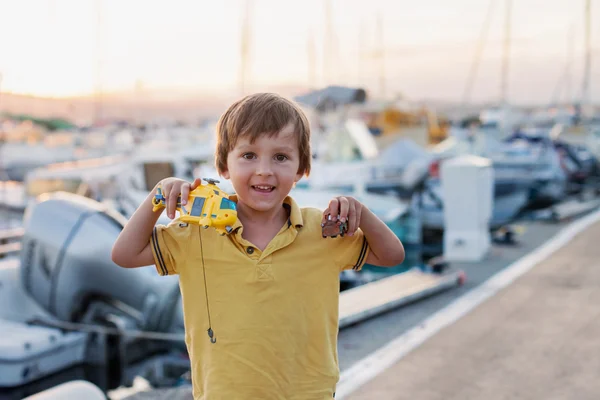 Felice bambino carino, ragazzo, giocare con l'elicottero su un porto — Foto Stock