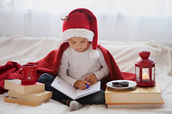 Entzückender kleiner Junge, der sich auf die Weihnachtsfeiertage vorbereitet — Stockfoto