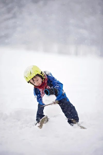 Menino feliz brincando na neve — Fotografia de Stock