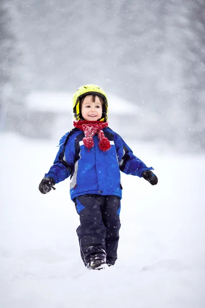 Gelukkig jongetje spelen in de sneeuw — Stockfoto