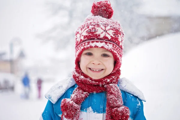 Mignon petit garçon en costume d'hiver bleu, jouant en plein air dans la neige — Photo