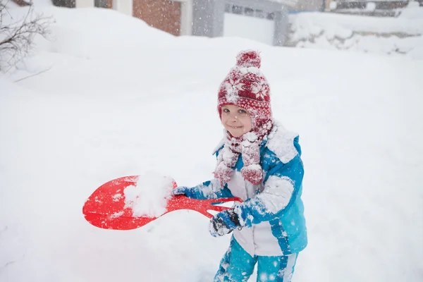 Carino bambino in tuta invernale blu, giocare all'aperto nella neve — Foto Stock