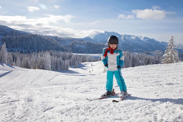 Adorabile bambino con giacca blu e casco, sci — Foto Stock