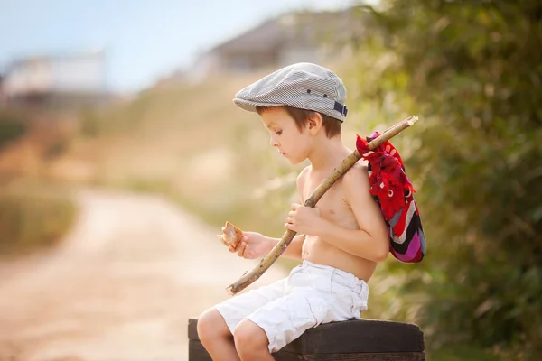 Cute little boy, sitting on a big old suitcase, vintage, holding — Stock Photo, Image
