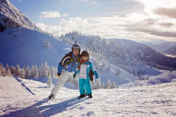 Familia feliz, padre e hijo, en ropa de invierno en la estación de esquí —  Fotos de Stock