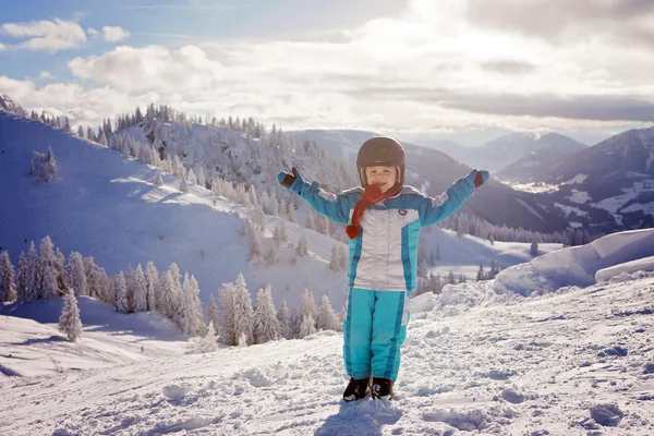 Schattige kleine jongen met blauwe jas en een helm, Skiën — Stockfoto