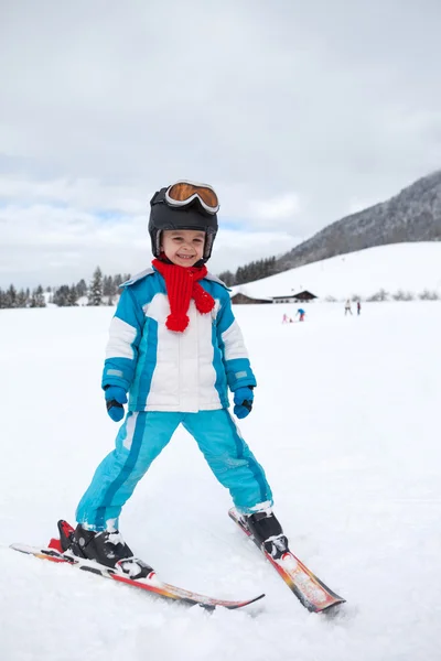 Adorable little boy with blue jacket and a helmet, skiing — Stock Photo, Image