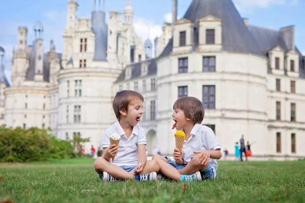 Two adorable boys in casual clothing, eating ice cream sitting o — Stock Photo, Image