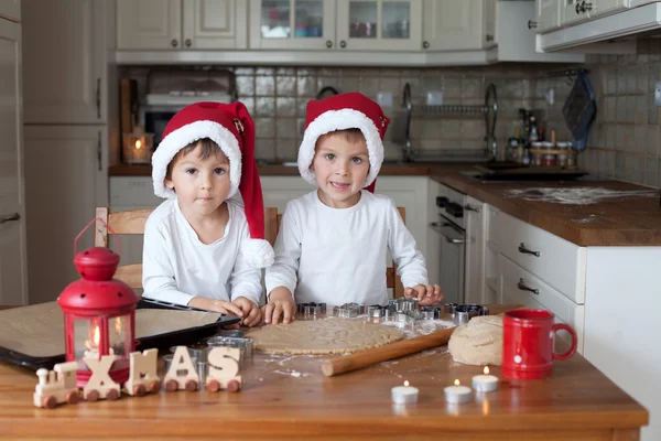 Δύο χαριτωμένα αγόρια με καπέλο santa, προετοιμασία cookies στην κουζίνα — Φωτογραφία Αρχείου