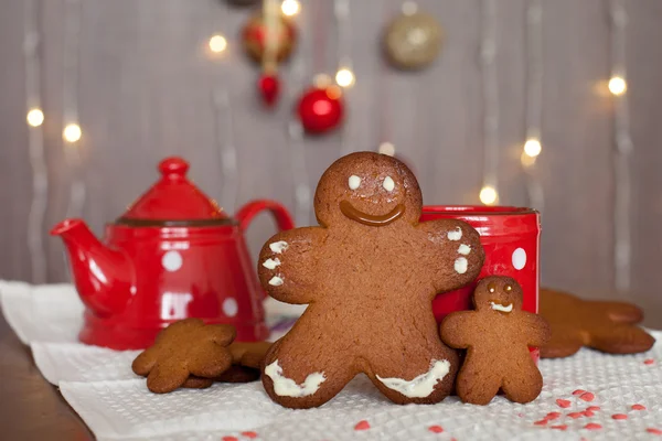 Smiling gingerbread man and a smaller one next to him standing i — Stock Photo, Image
