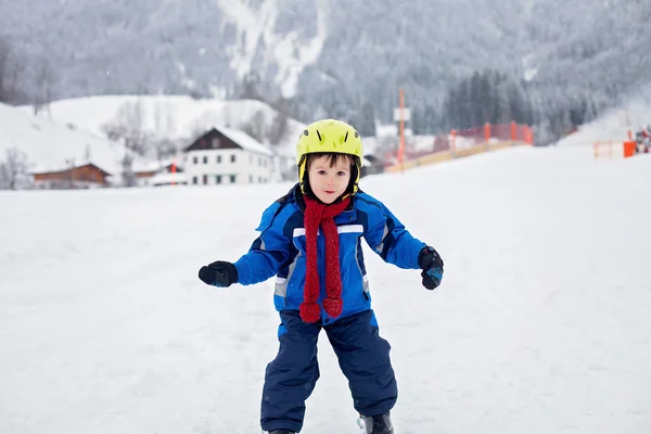 Adorabile bambino con giacca blu e casco, sci — Foto Stock