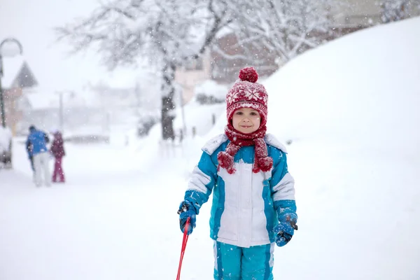 Mignon petit garçon en costume d'hiver bleu, jouant en plein air dans la neige — Photo