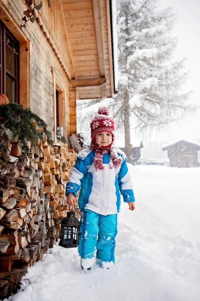Очаровательный маленький мальчик с фонариком, стоящий перед зимой — стоковое фото