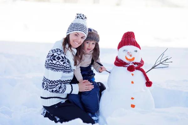 Счастливый красивый семейный снеговик в саду, зимой, мама — стоковое фото