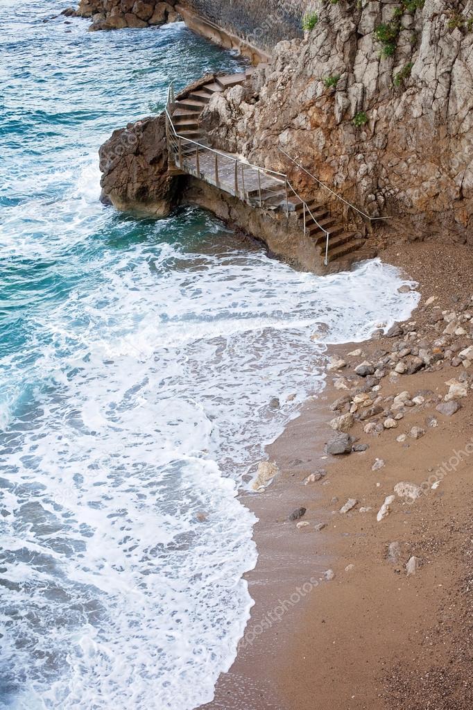 A staircase around a steep rock wall, connecting two beaches on 