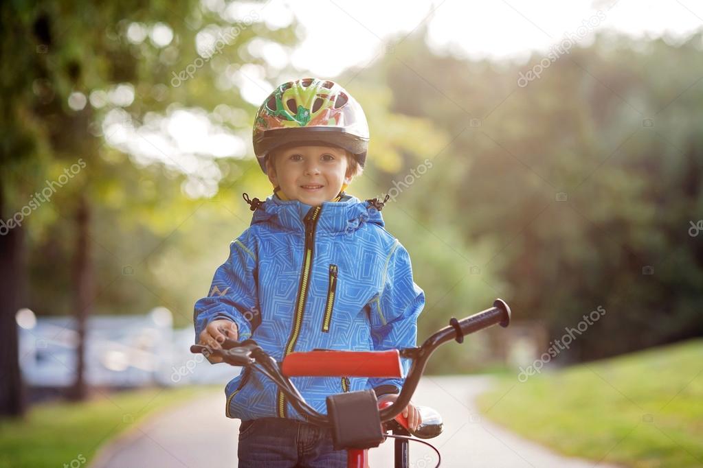 Cute little boy, toddler child, riding bike in a helmet