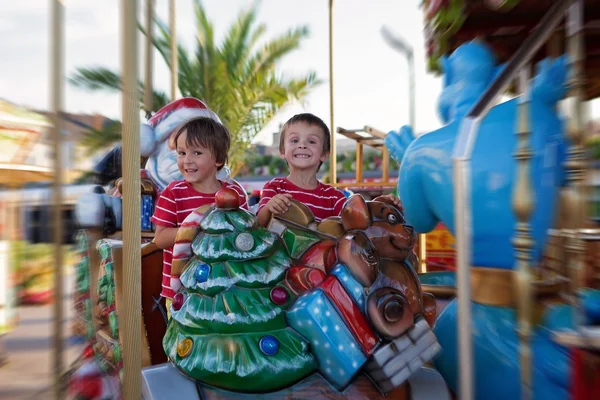 Dulces chicos, hermanos, montando en un trineo de Papá Noel en un alegre - —  Fotos de Stock