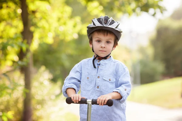 Cute boy, riding scooters, outdoor in the park, summertime — Stock Photo, Image