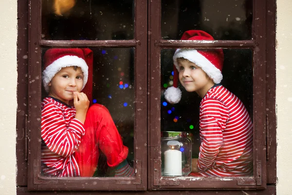Dois meninos bonitos, irmãos, olhando através de uma janela, esperando por S — Fotografia de Stock