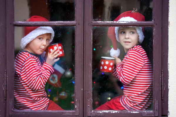 Dva roztomilý kluci, bratři, při pohledu přes okno, čekání na S — Stock fotografie