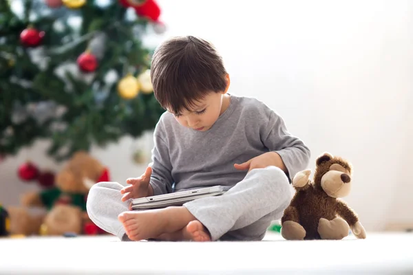 Lindo niño y su juguete mono, jugando en la tableta — Foto de Stock