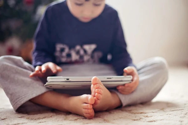 Söta små pojkar fötter, pojke spelar på Tablet PC — Stockfoto