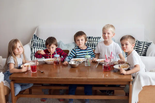 Fünf entzückende Kinder, die zu Hause Spaghetti essen — Stockfoto