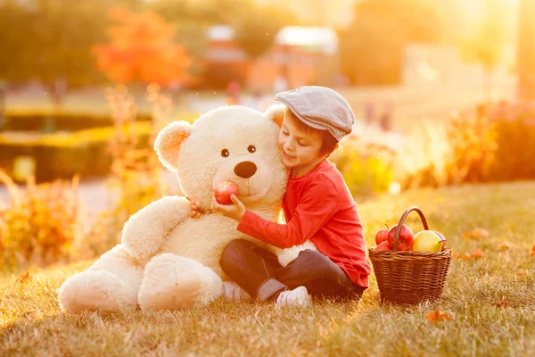 Entzückende kleine Junge mit seinem Teddybär Freund im Park auf su — Stockfoto