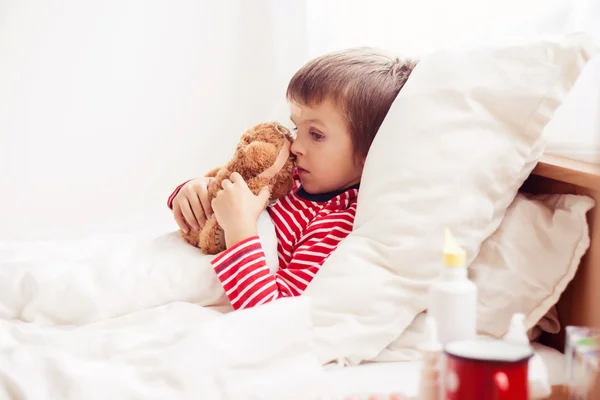 Niño enfermo acostado en la cama con fiebre, descansando — Foto de Stock