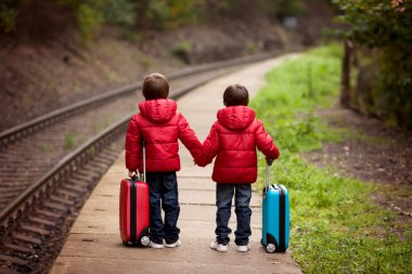 Suitca trenle bekleyen iki erkek bir tren istasyonu