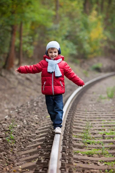 Mignon garçon marche sur un chemin de fer — Photo