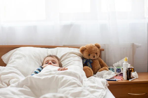 Enfant malade garçon couché au lit avec de la fièvre, se reposant — Photo