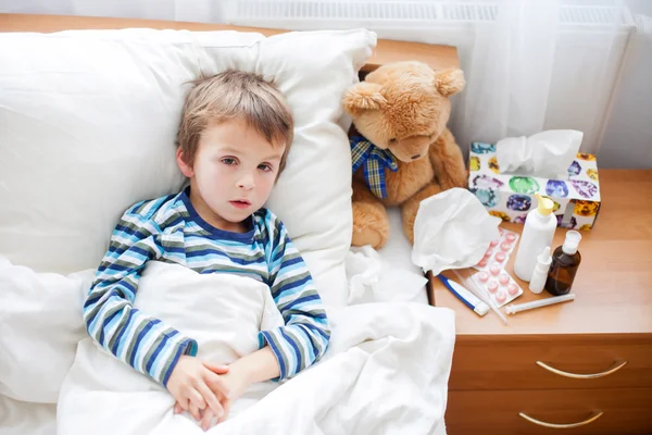 Niño enfermo acostado en la cama con fiebre, descansando — Foto de Stock
