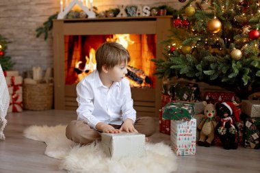 Noel 'de mutlu çocuk, hediyelerin, karın, Noel ışıklarının tadını çıkarıyor ve günün tadını çıkarıyor, kar, Noel, mutluluk.