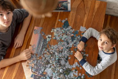 İki çocuk, çocuklar, bir tatil günü evde bulmaca çözüyorlar, evde birlikte oynuyorlar.