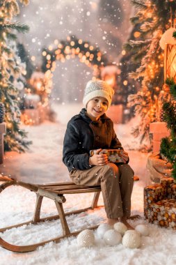 Noel 'de mutlu çocuk, hediyelerin, karın, Noel ışıklarının tadını çıkarıyor ve günün tadını çıkarıyor, kar, Noel, mutluluk.