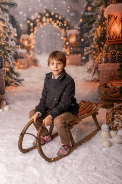 Noel 'de mutlu çocuk, hediyelerin, karın, Noel ışıklarının tadını çıkarıyor ve günün tadını çıkarıyor, kar, Noel, mutluluk.