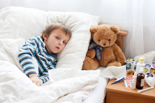 Niño enfermo acostado en la cama con fiebre, descansando —  Fotos de Stock