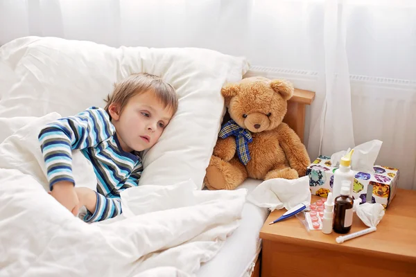 Niño enfermo acostado en la cama con fiebre, descansando — Foto de Stock