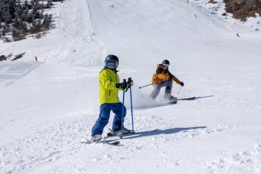 Çocuklu mutlu bir aile, Avusturya 'da kış kayak merkezinde kayak yapan okul çocukları.